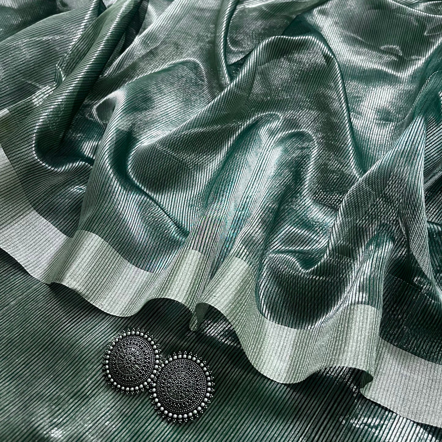 Dark green Maheshwari saree with silver zari lines all over