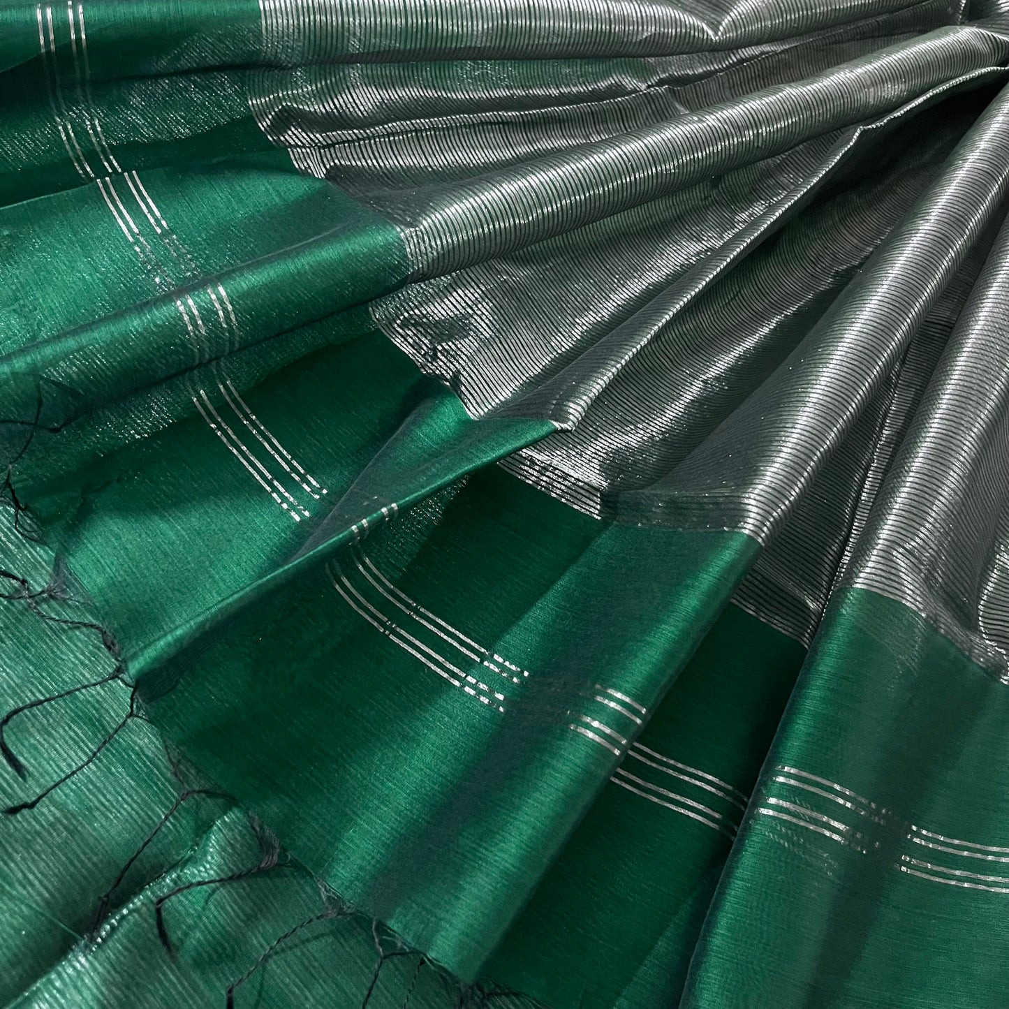 Dark green Maheshwari saree with silver zari lines all over