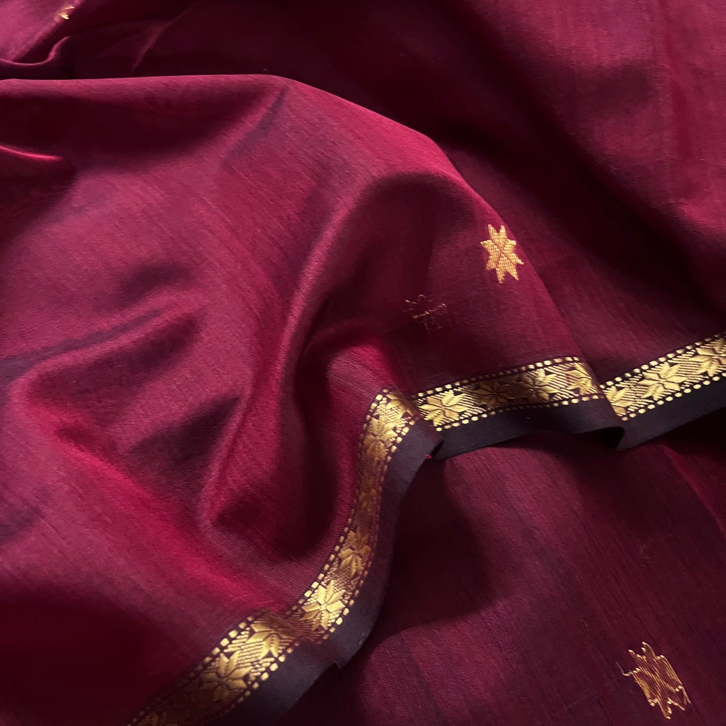 Maroon and black maheshwari saree with flower bootis all over
