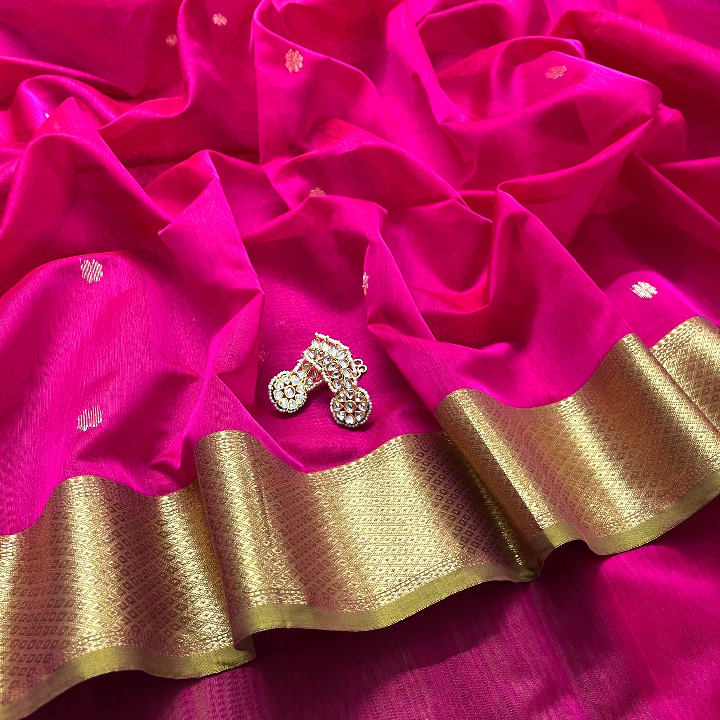 Pink and olive green Maheshwari saree with flower motifs on pallu