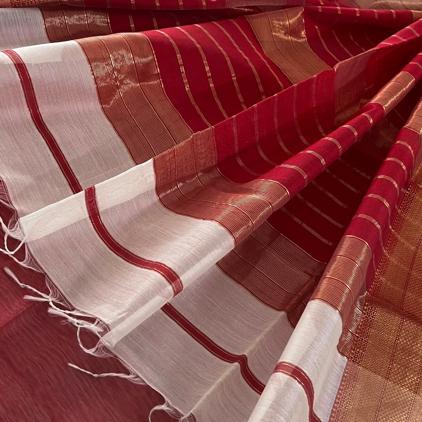 White and red Maheshwari saree with zari lines on pallu
