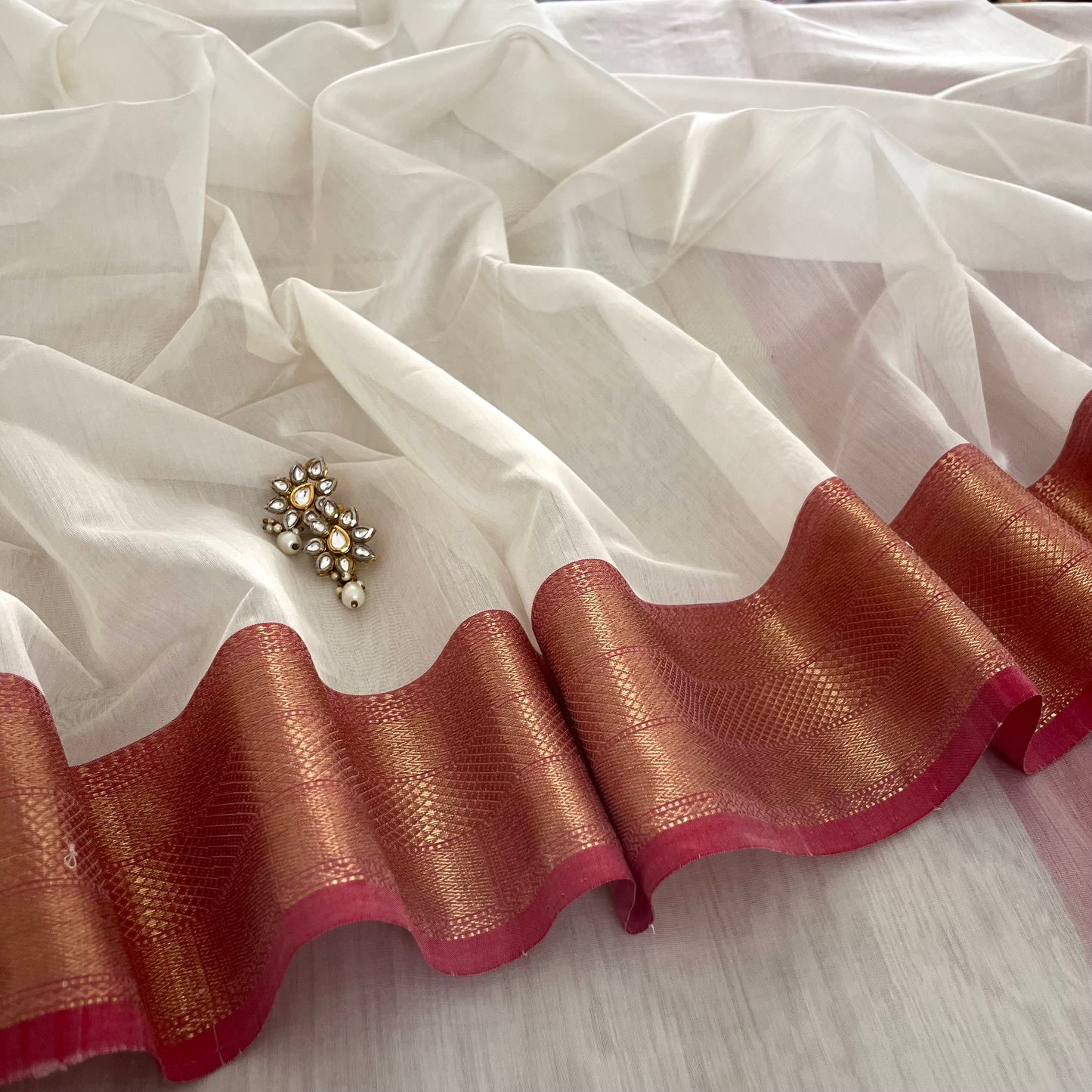 White and red Maheshwari saree with zari lines on pallu