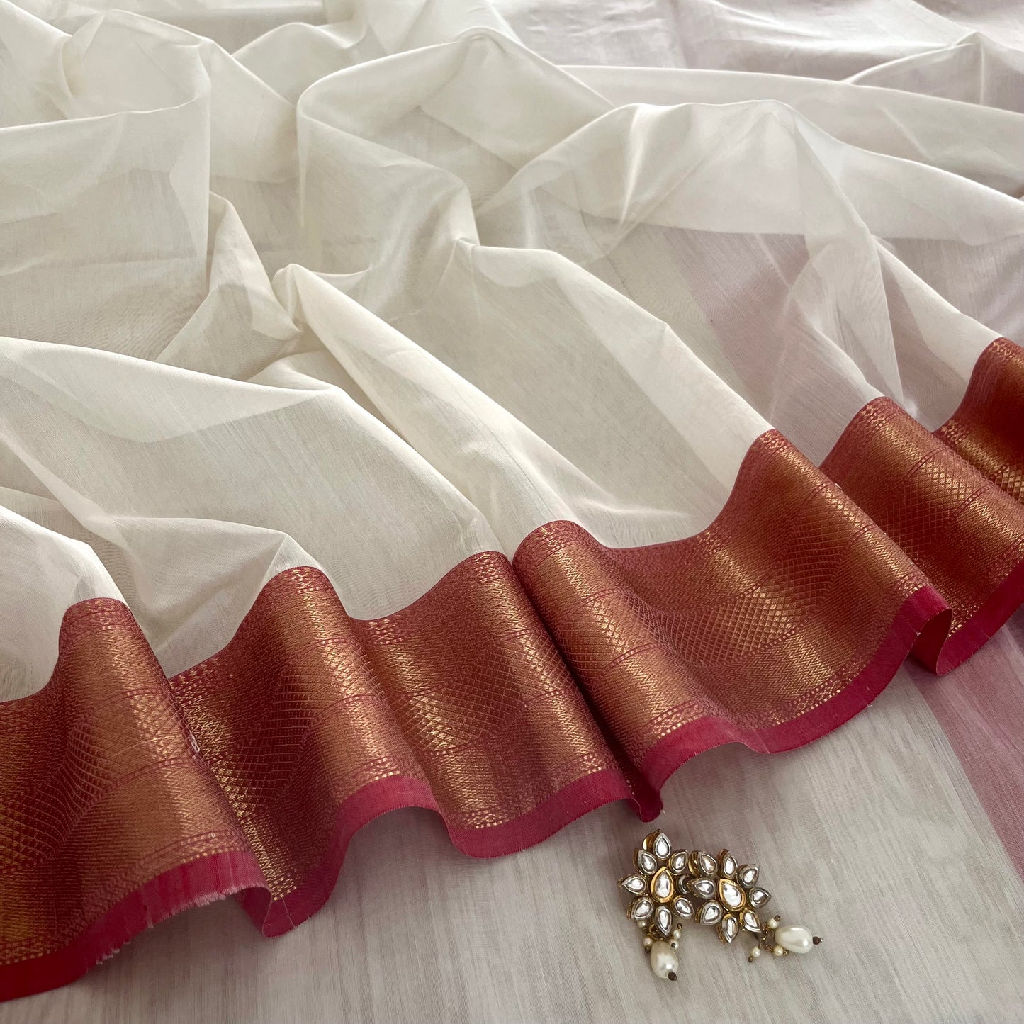 White and red Maheshwari saree with zari lines on pallu