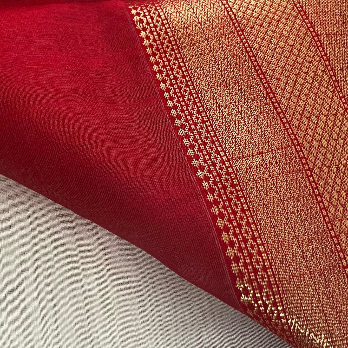 White and red Maheshwari saree with zari lines on pallu