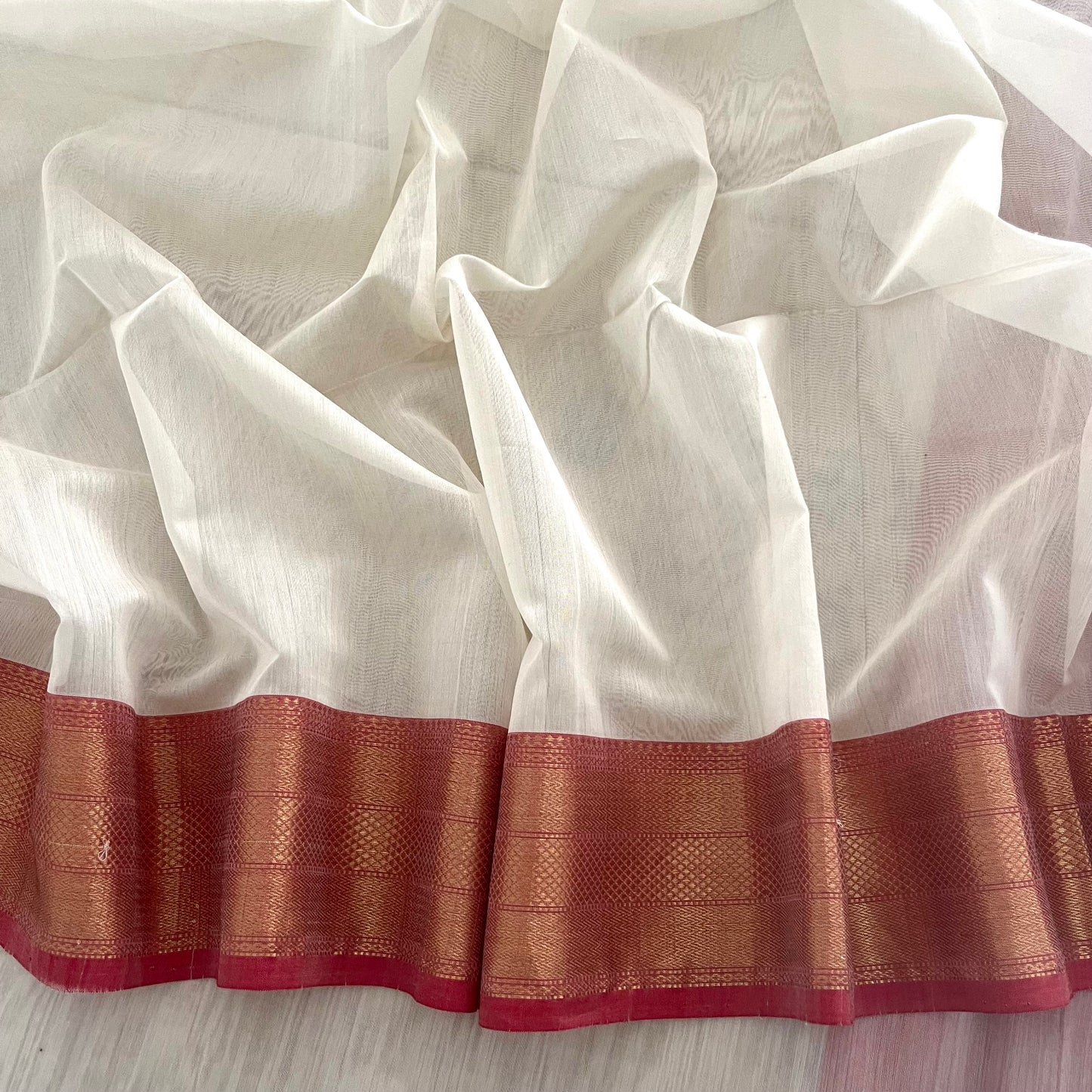 White and red Maheshwari saree with zari lines on pallu