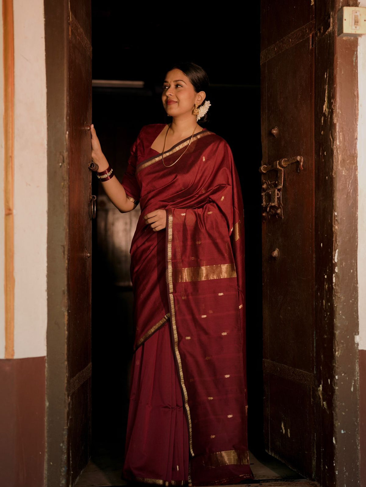 Deep maroon Maheshwari saree with flower bootis all over