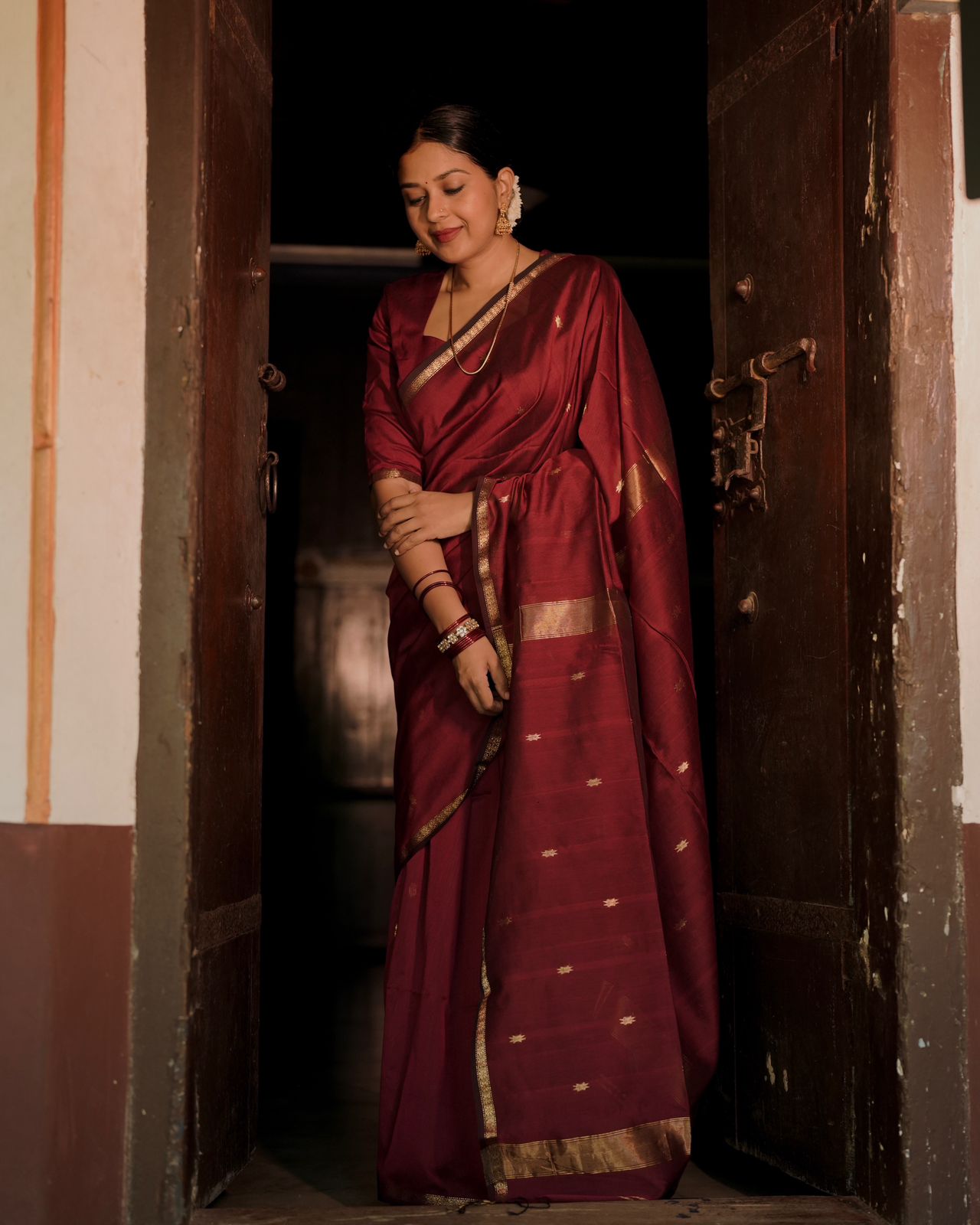 Deep maroon Maheshwari saree with flower bootis all over