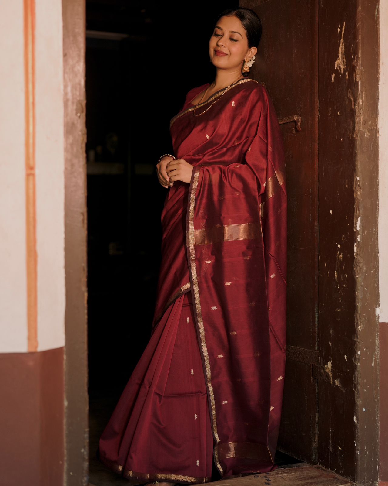 Deep maroon Maheshwari saree with flower bootis all over